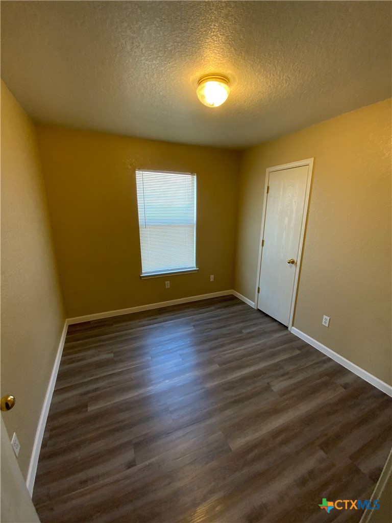 2602 Edgefield Street, Unit B Killeen, TX 76549 - Photo 9 of 12 an empty room with wooden floor and windows