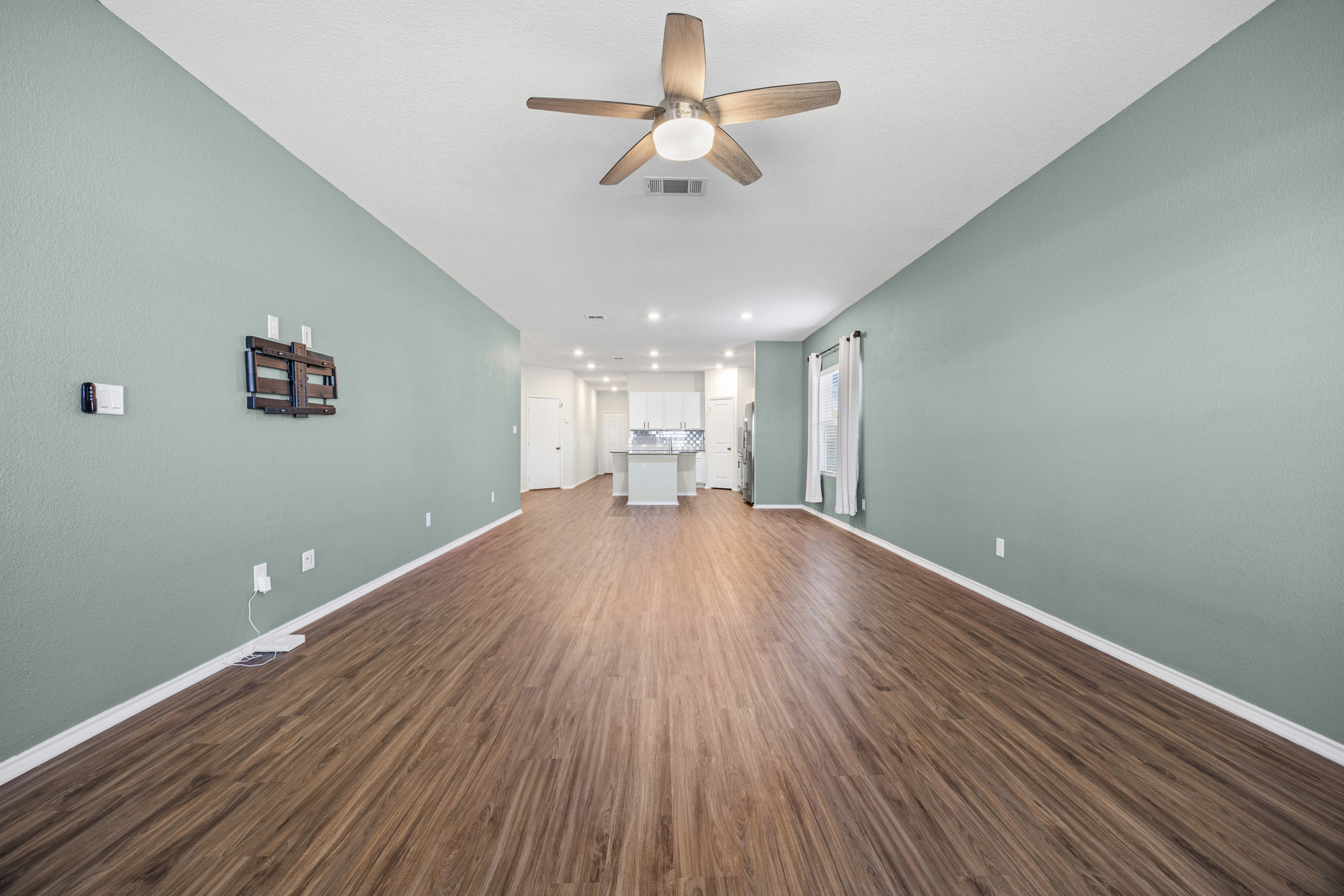 1609 Woolsey Way Leander, TX 78641 - Photo 14 of 29 Unfurnished living room with dark wood finished floors and ceiling fan