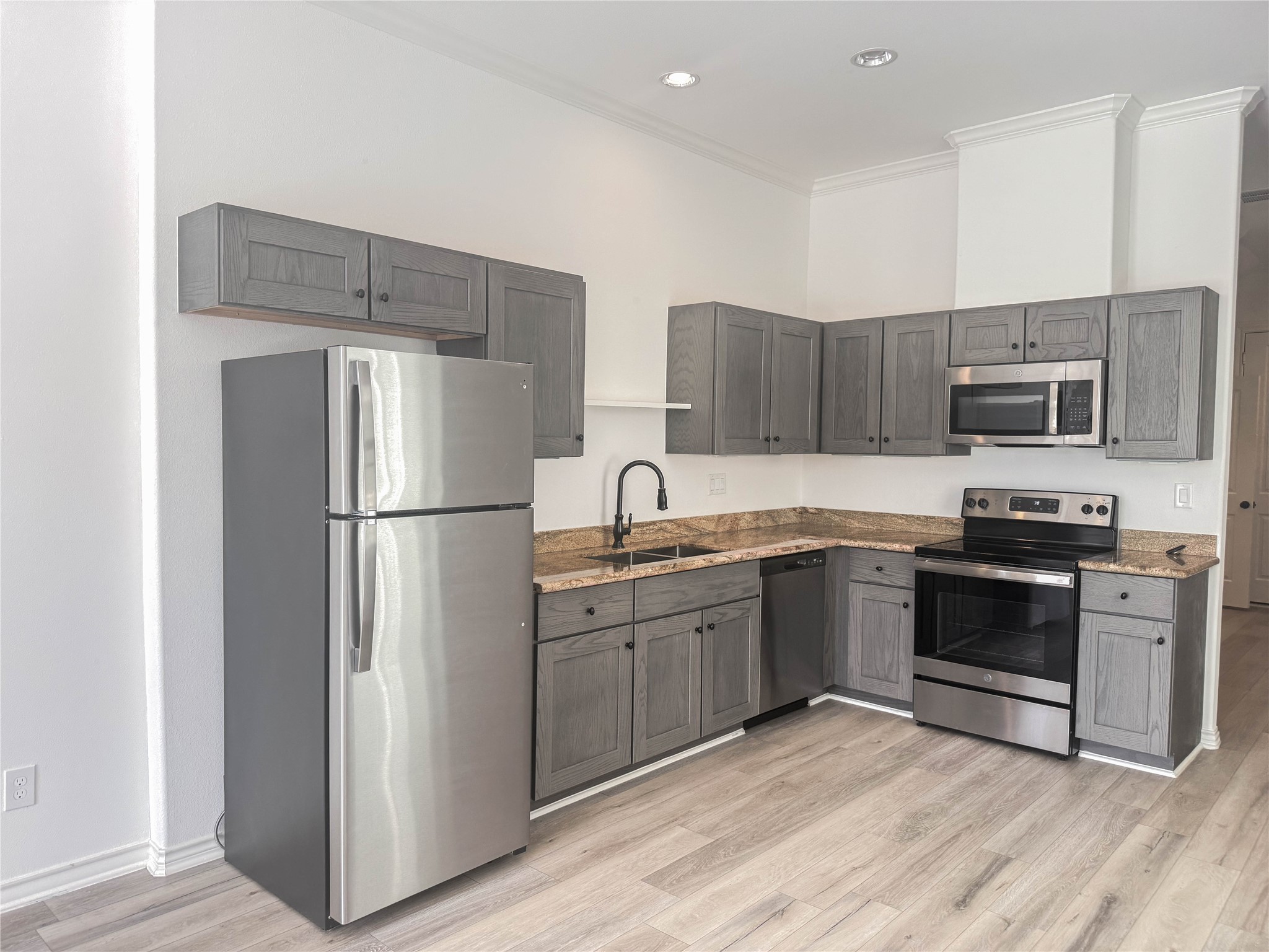 3233 Real Street, Unit A Houston, TX 77087 - Photo 2 of 12 a kitchen with stainless steel appliances granite countertop a refrigerator stove a sink and a microwave