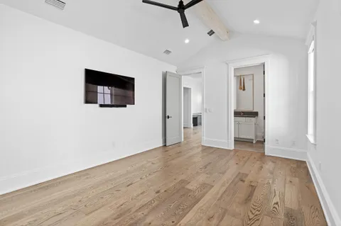 a view of a hallway with wooden floor and a living room