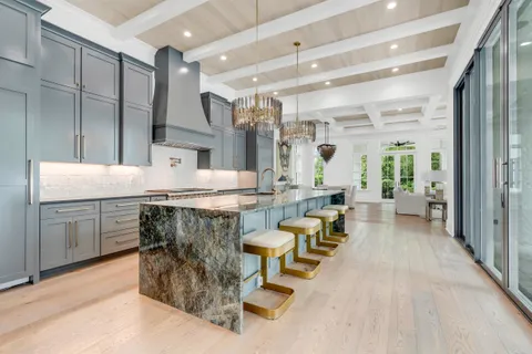 a large kitchen with kitchen island granite countertop a large counter top stainless steel appliances and cabinets