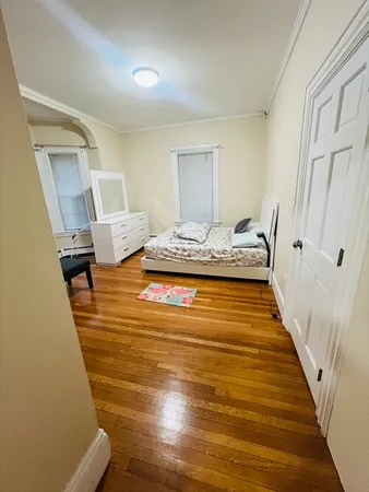 a bedroom with a bed and wooden floor