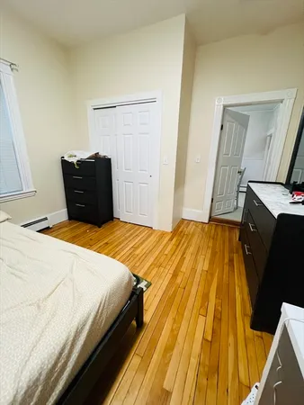 a bedroom with a bed and wooden floor