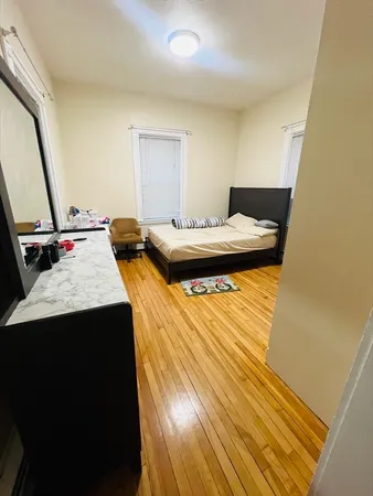 a bedroom with a bed and wooden floor