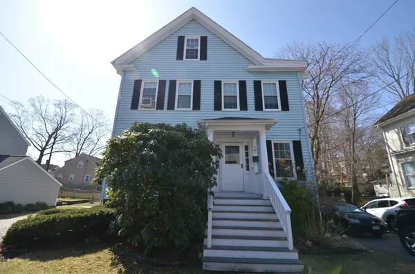 a front view of a house with a yard and trees