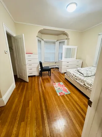 a bedroom with a bed and wooden floor