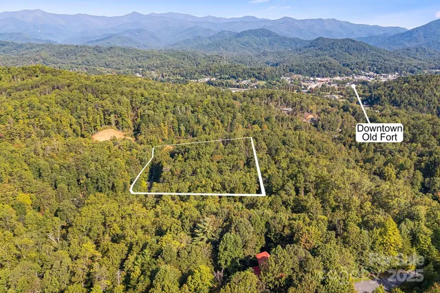 an aerial view of residential house with yard and mountain view in back