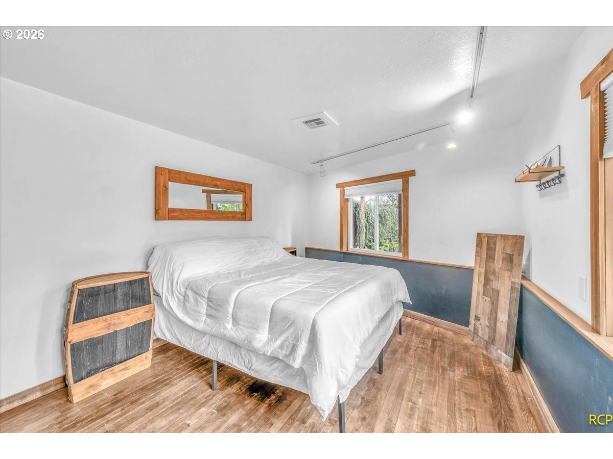 59887 Westhill Road St. Helens, OR 97051 - Photo 28 of 44 a bedroom with a bed and wooden floor