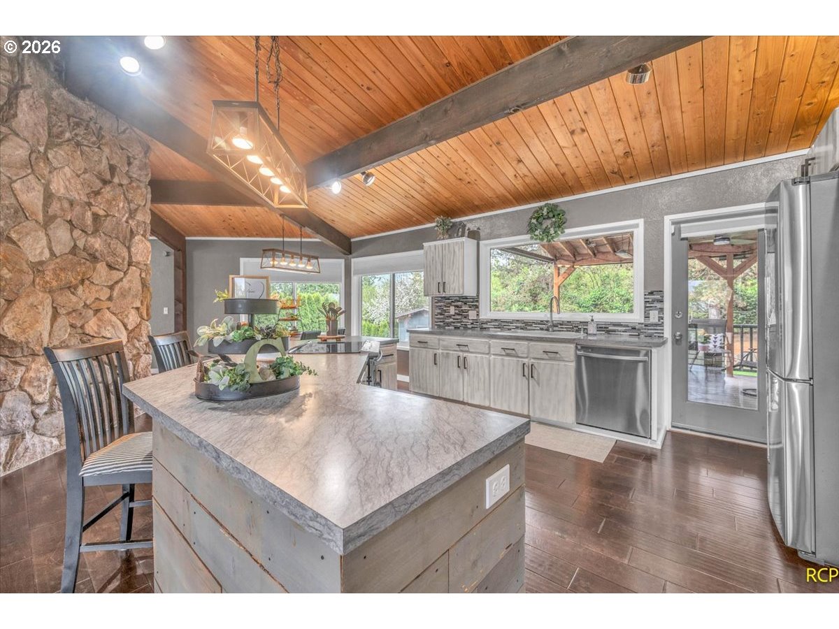 59887 Westhill Road St. Helens, OR 97051 - Photo 8 of 44 a kitchen with stainless steel appliances kitchen island granite countertop a table chairs and a large window