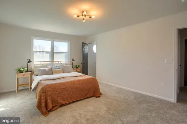 a large bed sitting in a bedroom next to a window