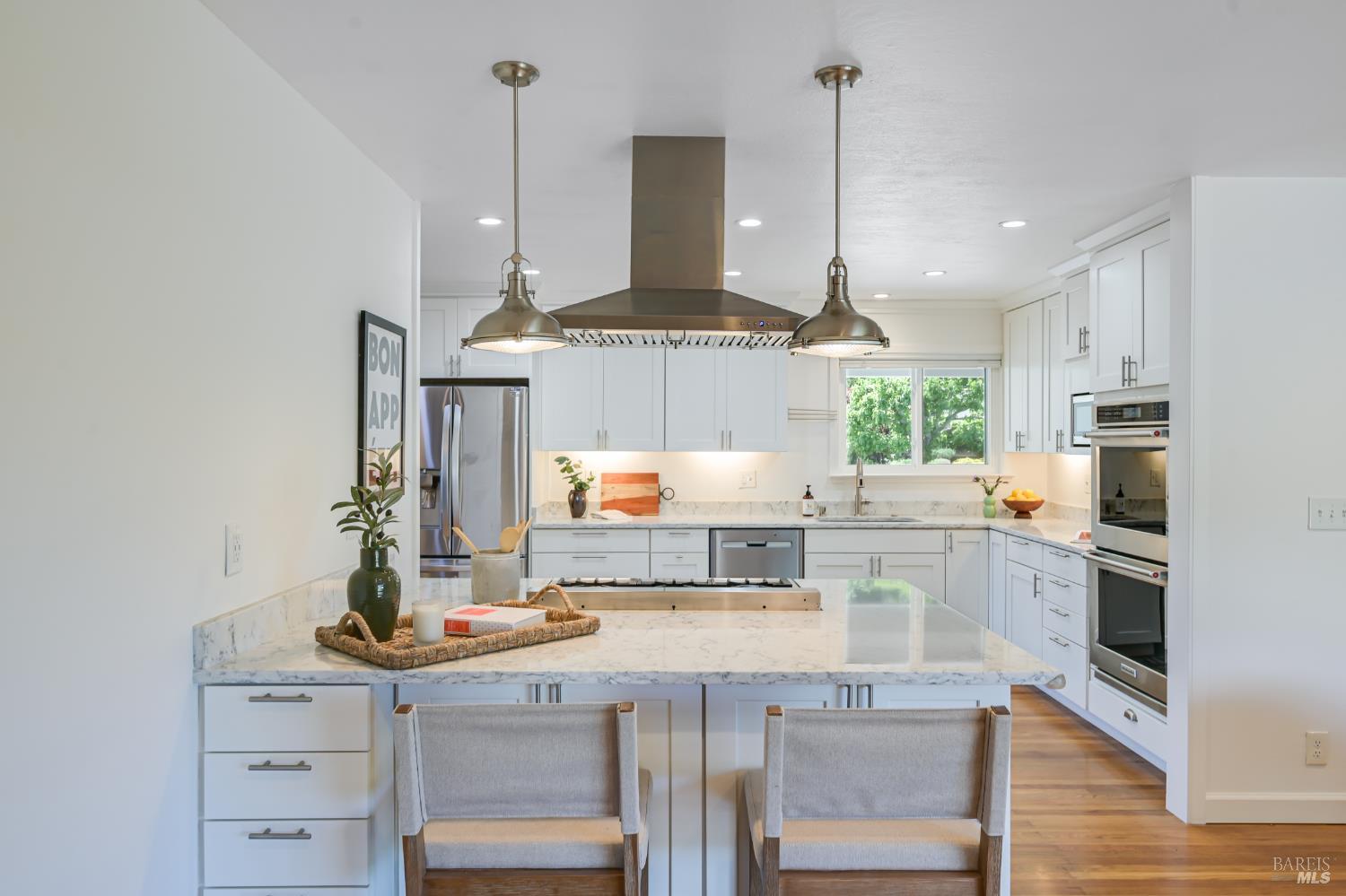 16 Wallace Way San Rafael, CA 94903 - Photo 7 of 44 a kitchen with kitchen island granite countertop a stove a sink and white cabinets with wooden floor