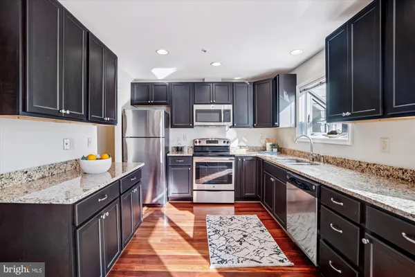 a kitchen with stainless steel appliances granite countertop a stove a sink dishwasher a refrigerator and a oven