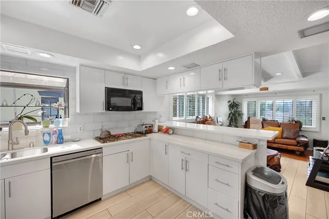 a kitchen with stainless steel appliances kitchen island granite countertop a sink refrigerator and microwave