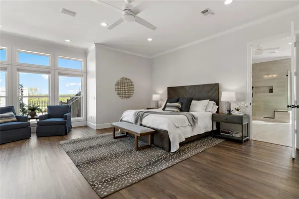 a bedroom with a large bed and wooden floor