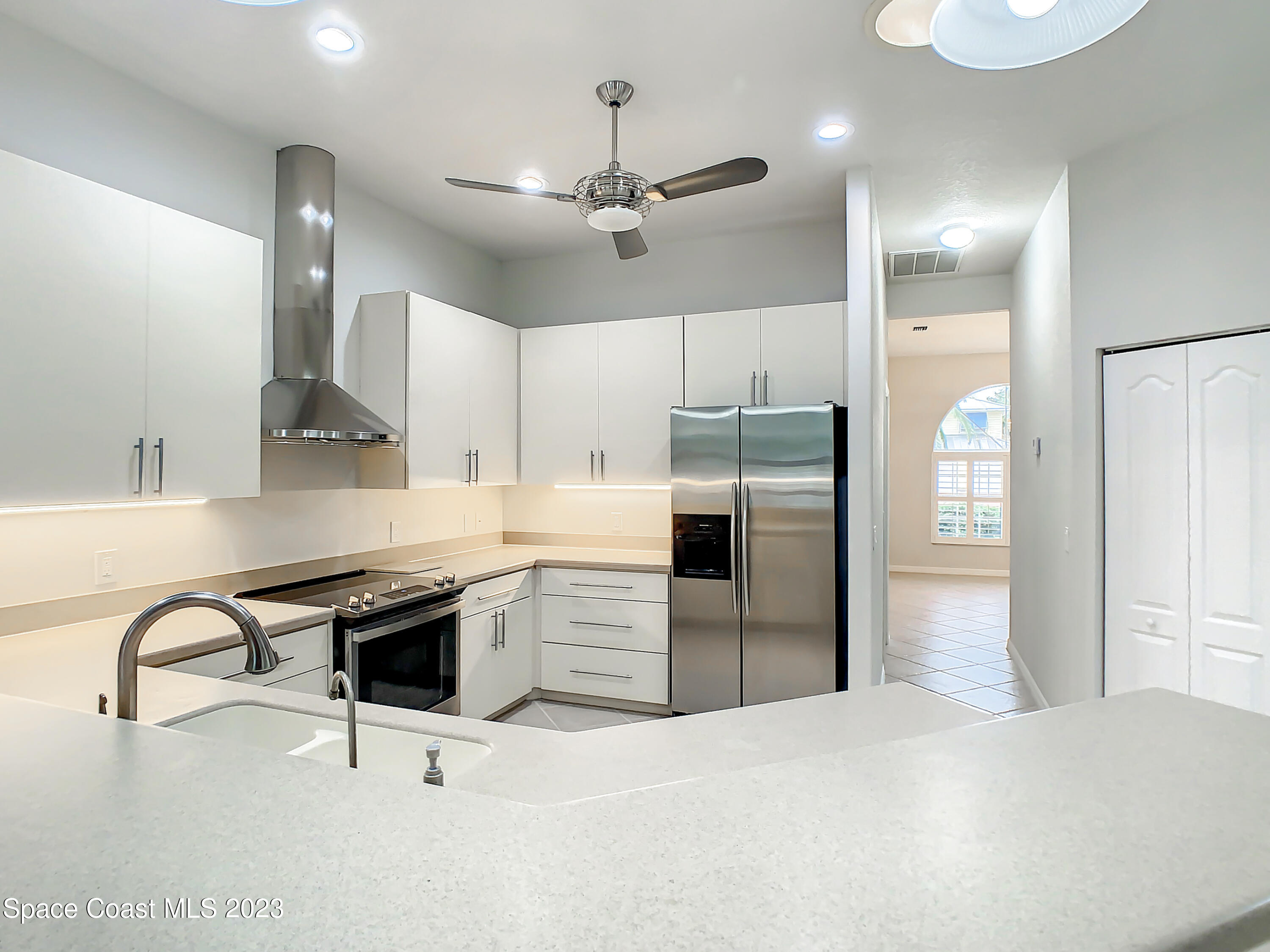 1965 Gates Road Merritt Island, FL 32952 - Photo 16 of 54 a kitchen with stainless steel appliances kitchen island granite countertop a stove a refrigerator and a sink with wooden floor