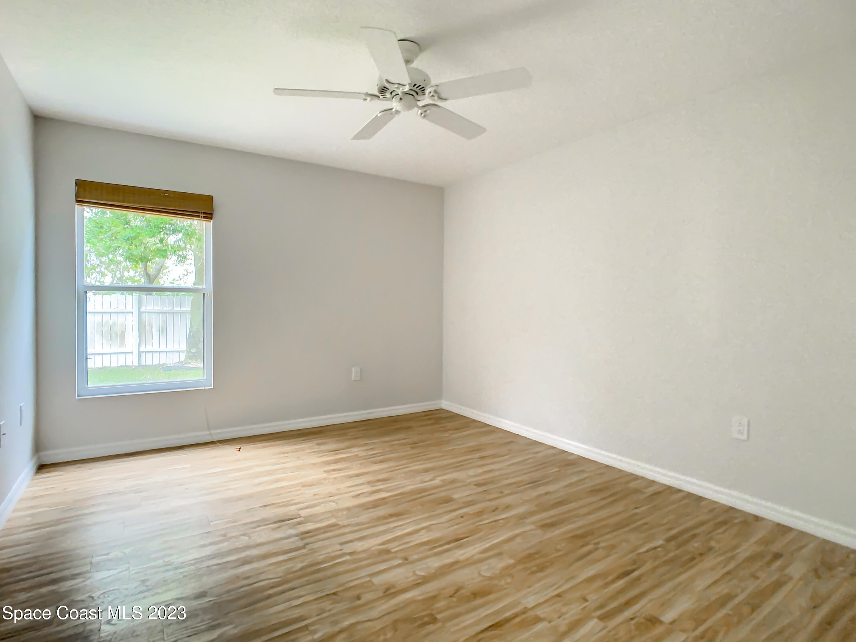 1965 Gates Road Merritt Island, FL 32952 - Photo 22 of 54 an empty room with wooden floor and windows