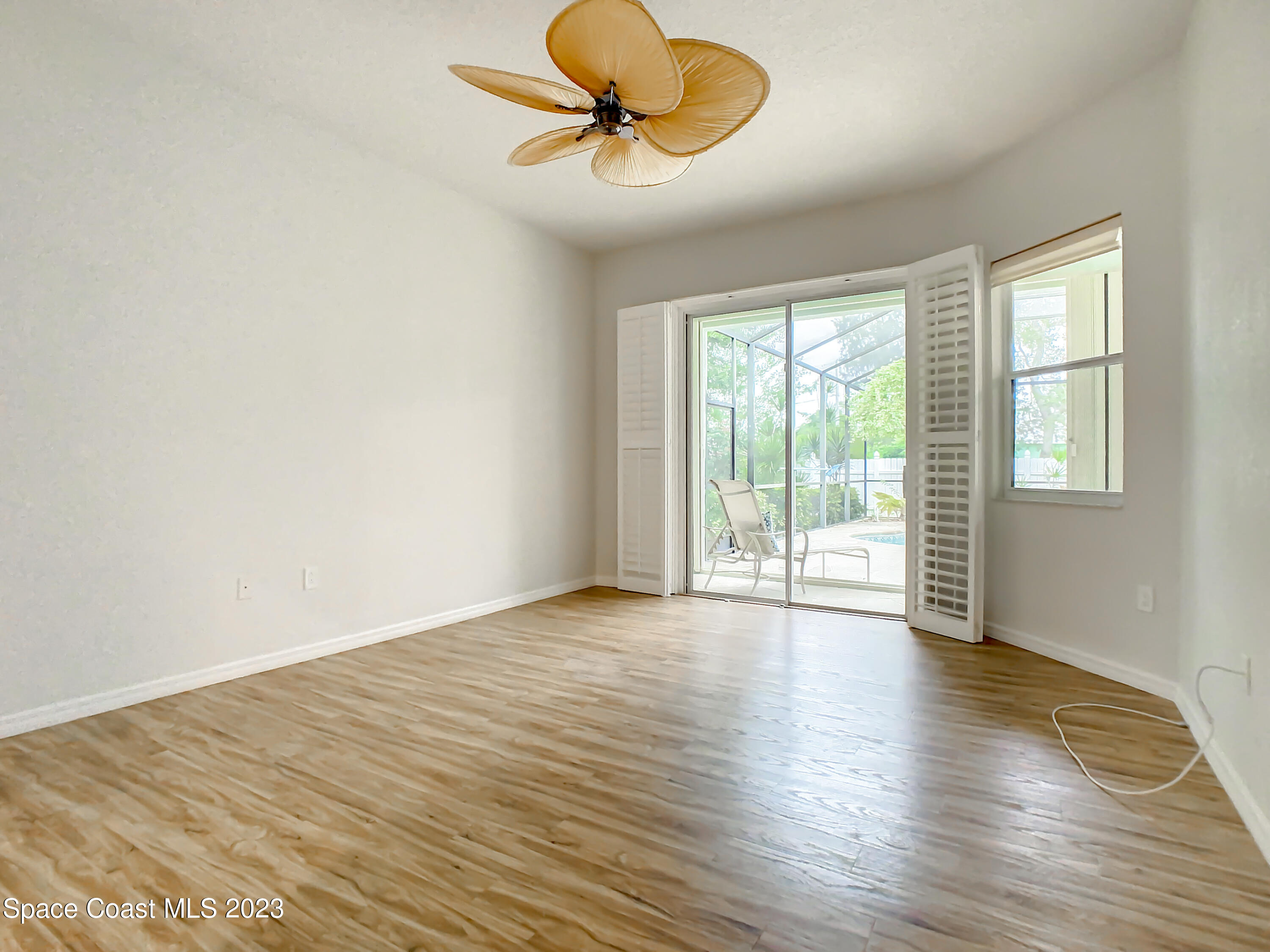 1965 Gates Road Merritt Island, FL 32952 - Photo 27 of 54 an empty room with wooden floor and windows