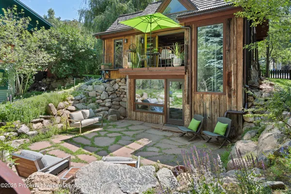 a view of a chair and table in backyard of the house