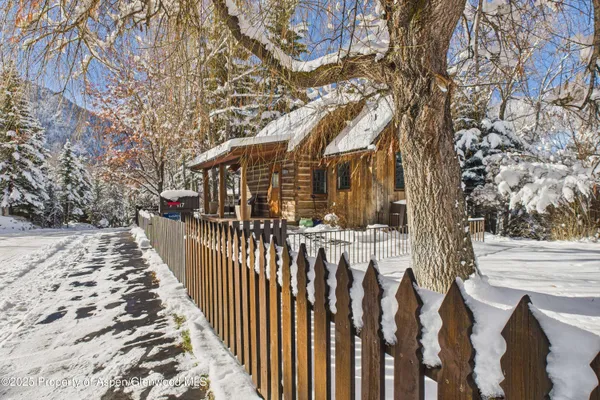 a view of a pathway of a house with wooden fence