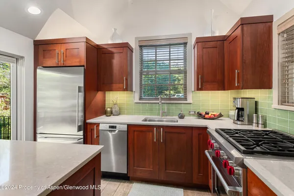 a kitchen with stainless steel appliances granite countertop a stove a sink dishwasher and a refrigerator