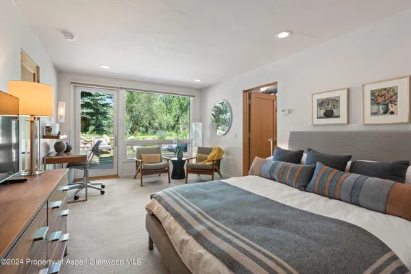 a bedroom with furniture and a large window