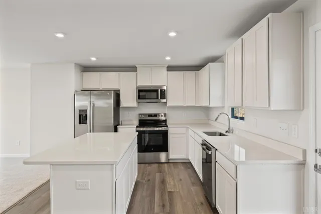 a kitchen with a sink a counter top space stainless steel appliances and cabinets