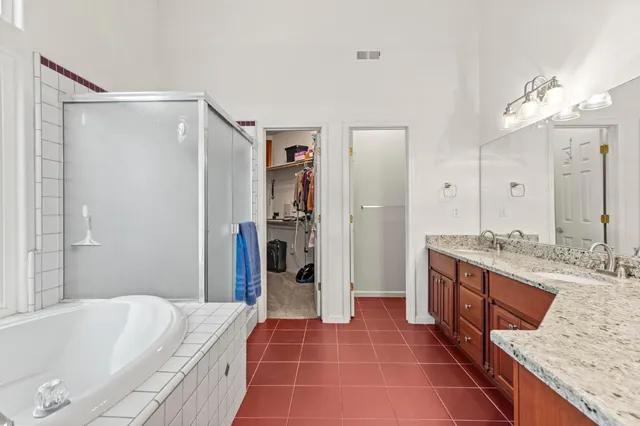 a spacious bathroom with a granite countertop tub sink and mirror