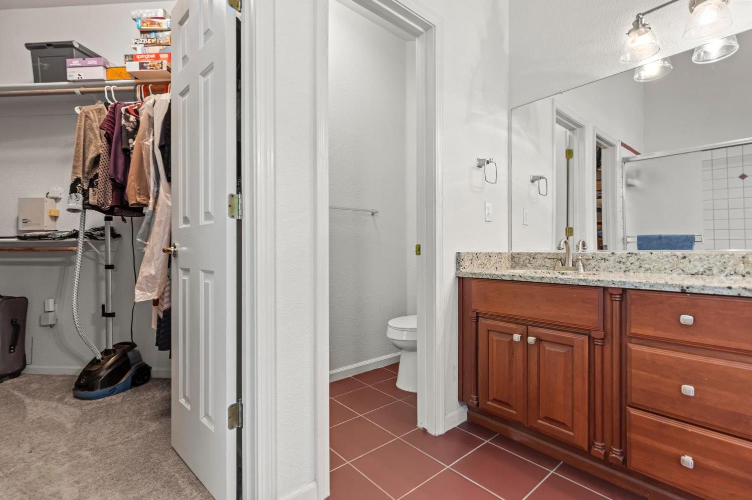 1090 Portola Valley Road Yuba City, CA 95993 - Photo 14 of 42 a bathroom with a granite countertop sink a toilet and a mirror