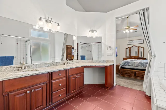 a spacious bathroom with a granite countertop sink a mirror and a