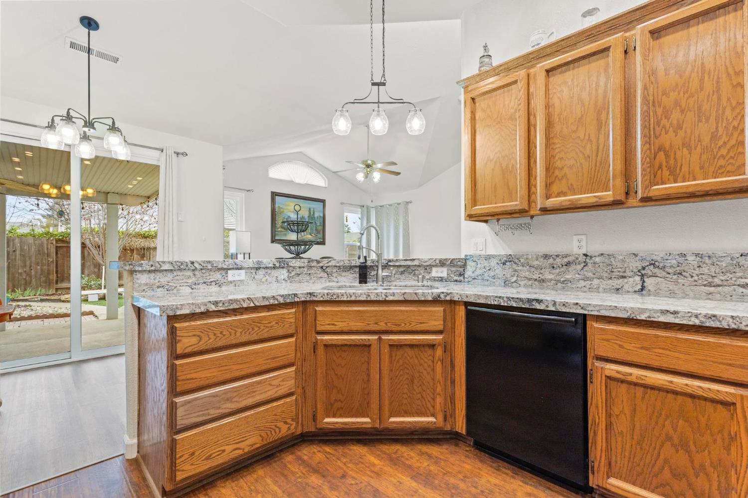 1090 Portola Valley Road Yuba City, CA 95993 - Photo 25 of 42 a kitchen with granite countertop a sink cabinets and wooden floor