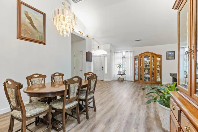 a view of a a dining room with furniture window and wooden floor