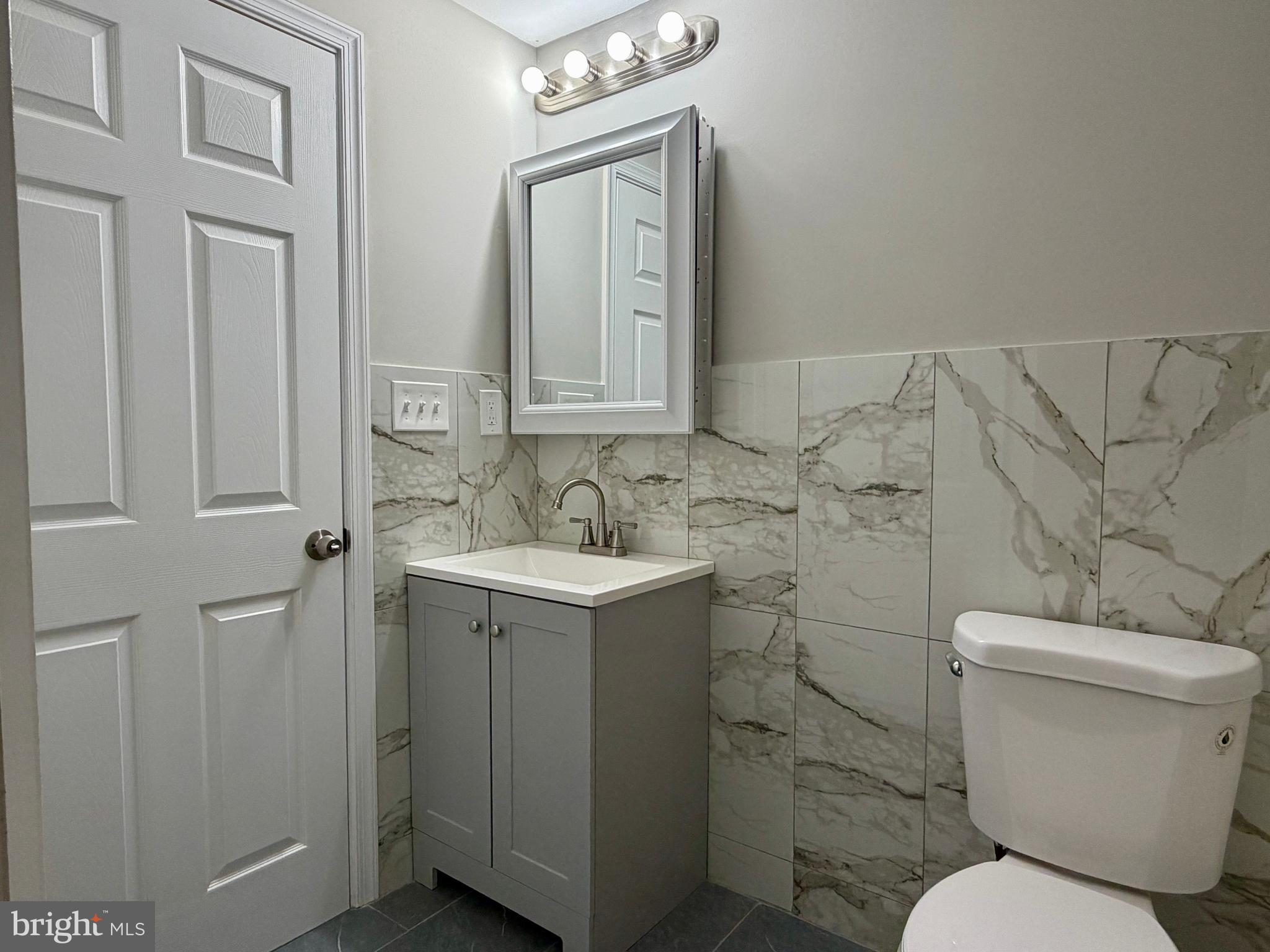 1727 Dallas Street, Unit 2 Philadelphia, PA 19126 - Photo 11 of 15 a bathroom with a toilet sink and mirror