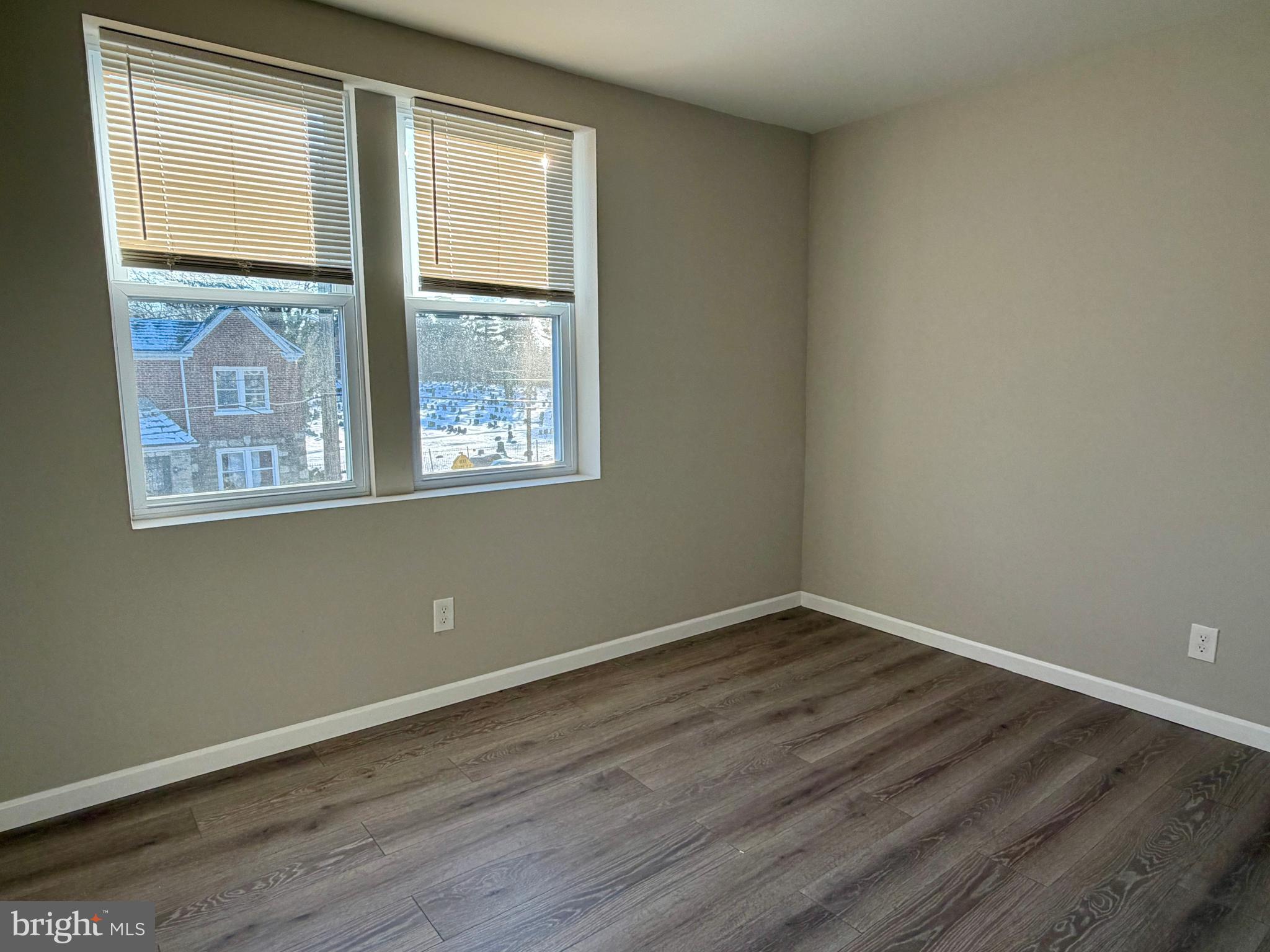 1727 Dallas Street, Unit 2 Philadelphia, PA 19126 - Photo 7 of 15 a view of an empty room with wooden floor and a window