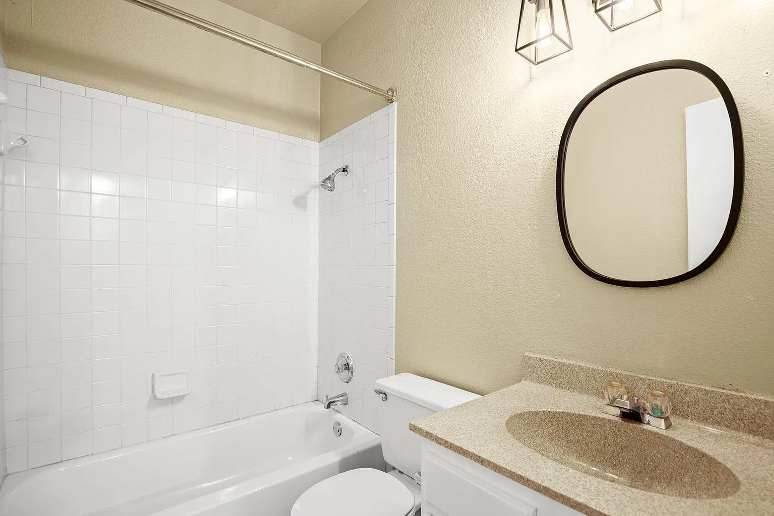 1812 Maple Avenue, Unit A Austin, TX 78702 - Photo 8 of 10 a bathroom with a granite countertop sink a mirror and a bathtub