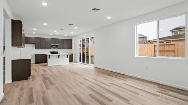 a view of kitchen with stainless steel appliances kitchen island wooden floor and window