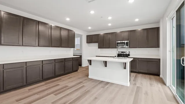 a kitchen with stainless steel appliances granite countertop a stove a sink and a refrigerator