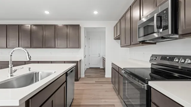 a kitchen with stainless steel appliances a sink stove and cabinets