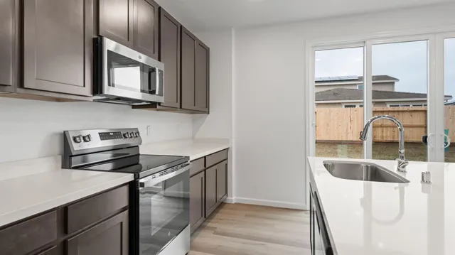 a kitchen with stainless steel appliances granite countertop a sink and a microwave