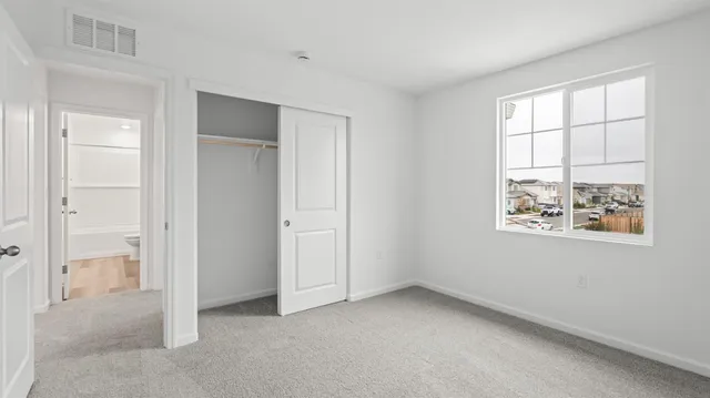 an empty room with windows and closet