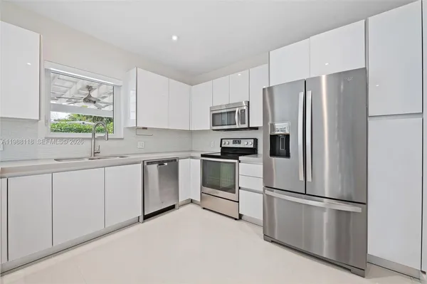 a kitchen with stainless steel appliances white cabinets and a refrigerator