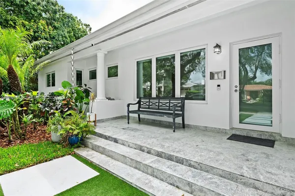a white bench sitting in front of a house