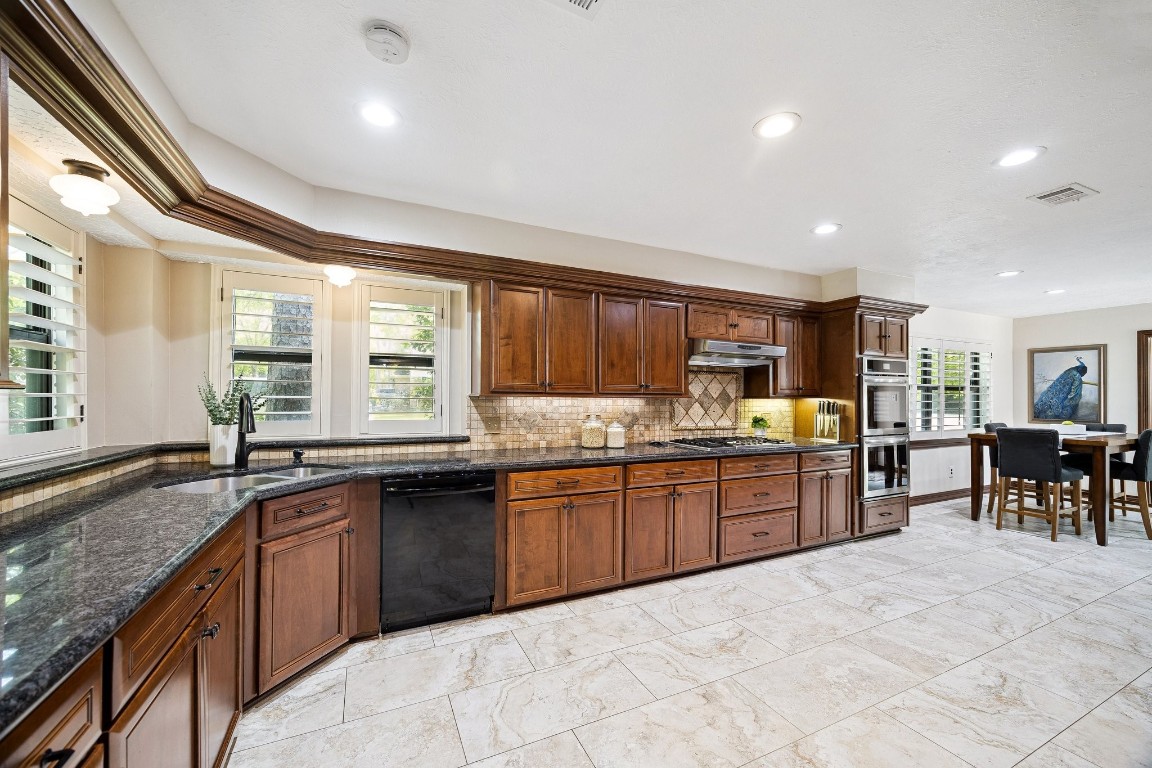 2 Chatterbird Spring, TX 77380 - Photo 14 of 40 a large kitchen with granite countertop lots of counter space sink and dining table