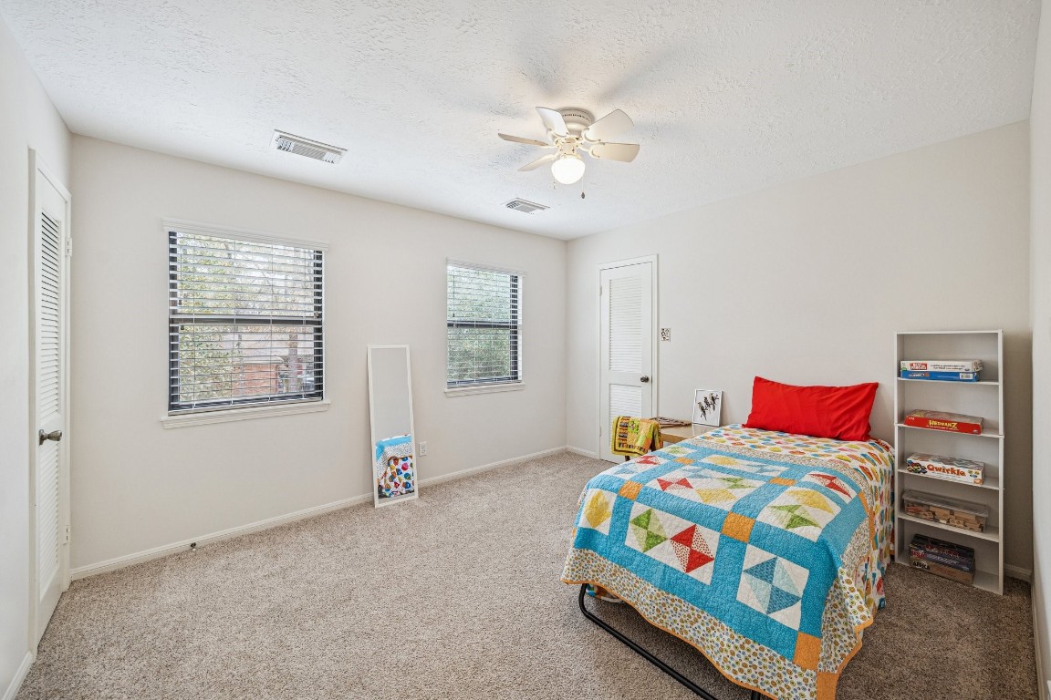 2 Chatterbird Spring, TX 77380 - Photo 25 of 40 a bedroom with a bed and a chandelier