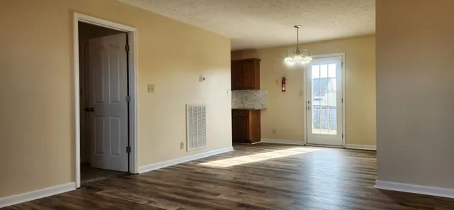 an empty room with wooden floor and mirror