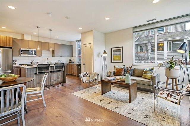 a living room with stainless steel appliances kitchen island granite countertop furniture and a view of kitchen