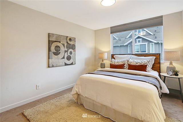 a bedroom with a bed and painting on the wall