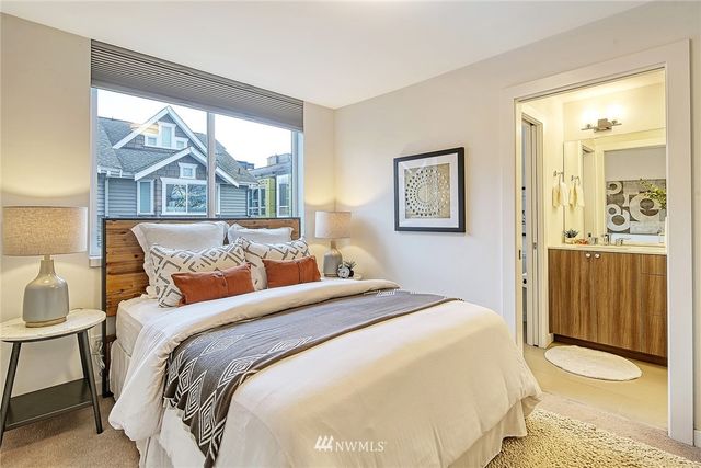 a bedroom with a bed and a painting on the wall