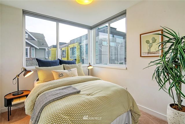 a bedroom with a bed and a large window with outer view