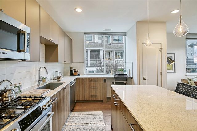 a kitchen with stainless steel appliances a sink stove and microwave