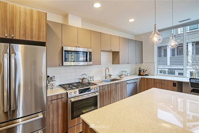 a kitchen with a refrigerator a stove a sink and a microwave